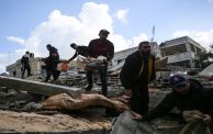 (Getty) فلسطينيون فوق الأنقاض في دير البلح