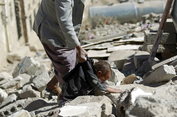 انتشال جثة طفل من بين أنقاض منازل دمرتها غارات سعودية في اليمن (محمد عويس/ أ.ف.ب)