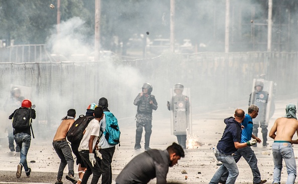 اشتباكات بين محتجين وأفراد من الشرطة الفنزويلية (الأناضول)