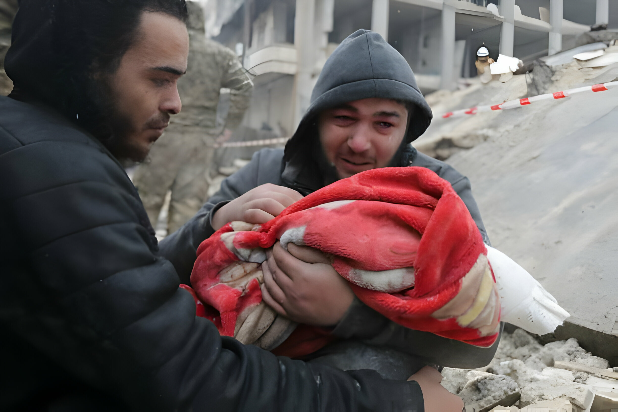 رجل سوري يبكي وهو يحمل جثة ابنه الذي قتله الزلزال في بلدة جنديرس بمحافظة حلب