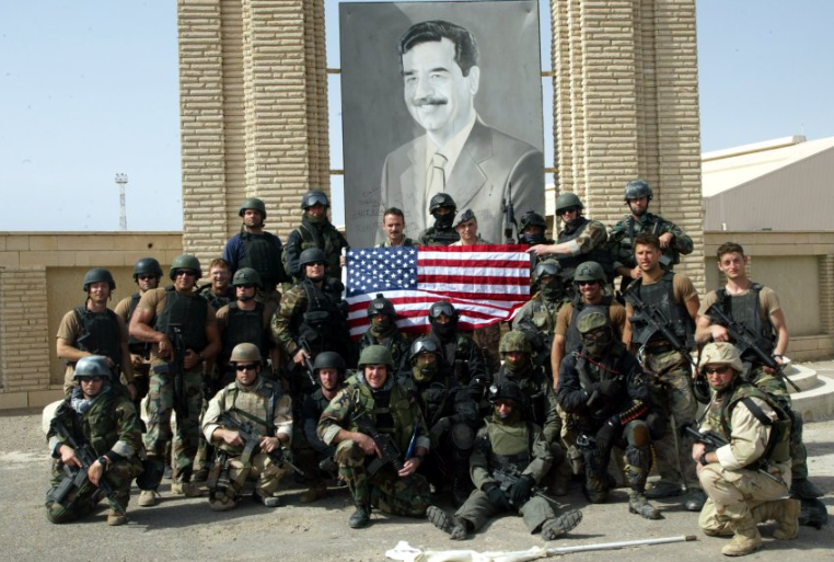 جنود القوات الأمريكية أمام صورة صدام حسين في غزو العراق