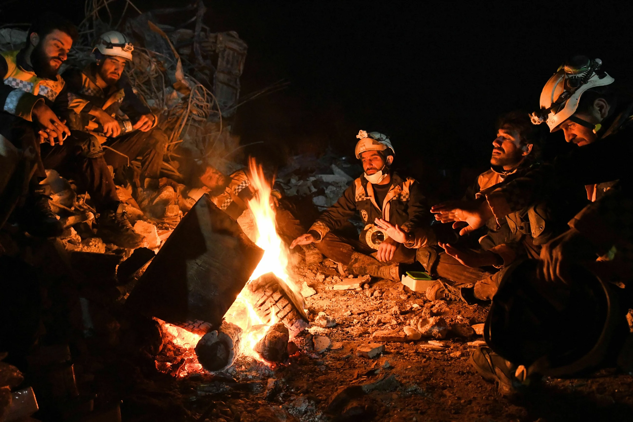 متطوعو الخوذ البيضاء في استراحة بعد نهار طويل من البحث عن الناجين وانتشال الضحايا شمال غربي سوريا
