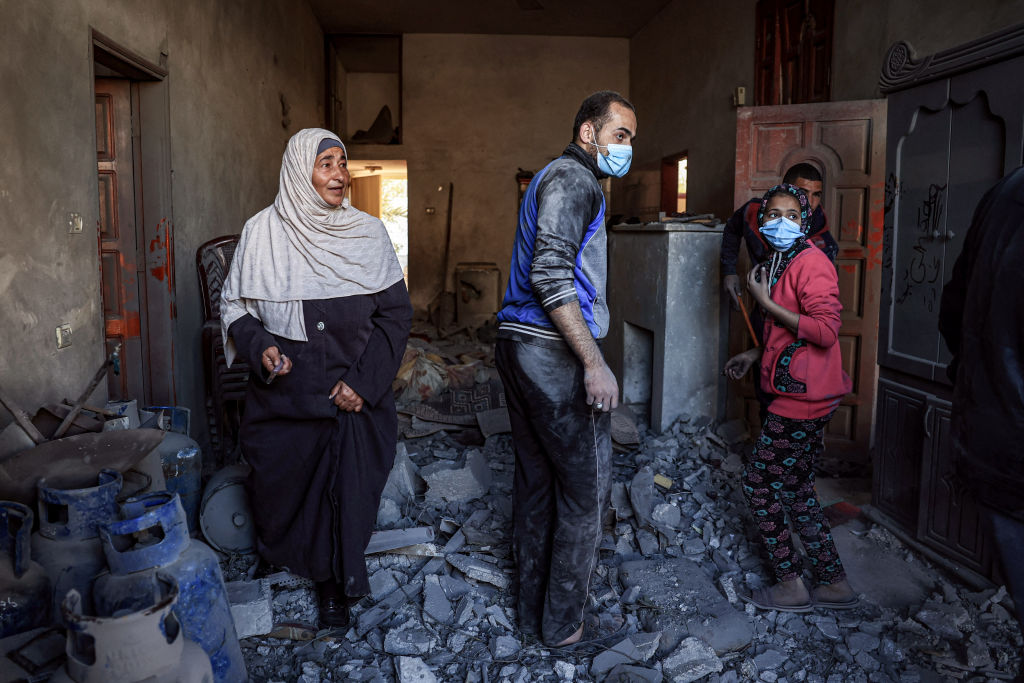 مواطنون في منزلهم الذي دمّره القصف الإسرائيلي على رفح جنوب قطاع غزة