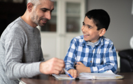 Muslim father helping son with homework