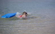 Boy falls into the water from his surfboard