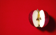 A cut apple on a red background.