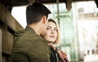 Young couple, underneath bridge, face to face, pensive expression