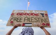متظاهر في ماليزيا يرفع لوحة مؤيدة لفلسطين