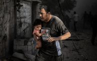 فلسطيني يحمل ابنته بعد غارة إسرائيلية على مخيم المغازي