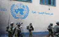جنود إسرائيليون أمام مقر الأونروا في غزة (رويترز)