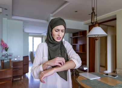 Muslim woman scratching her hand skin; dry skin, allergic skin