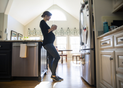 Pregnant woman drinking tea in kitchen