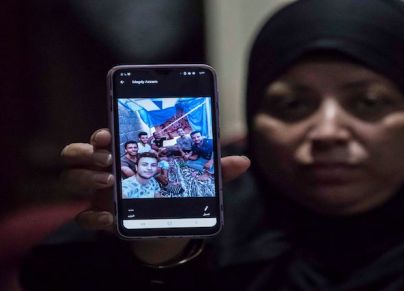 مصرية ترفع صورة لأقاربها الذين فُقدوا في ليبيا أثناء محاولتهم الوصول إلى أوروبا في 2020
