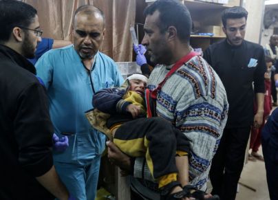 مسعفون يعالجون جرحى في مستشفى شهداء الأقصى بدير البلح (GETTY)