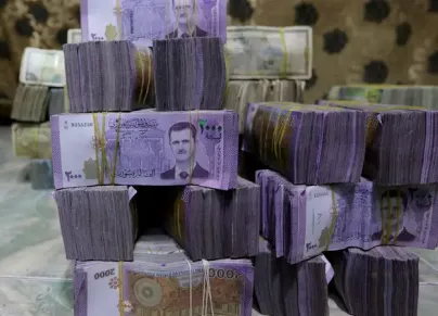 يستمر تراجع قيمة الليرة السورية بسبب سياسات النظام (رويترز)