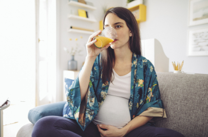 Happy pregnant women drinking orange juice