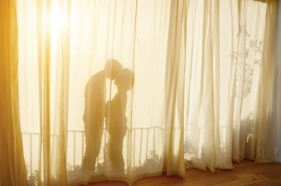 40's Couple In Apartment kissing behind curtain in the sun