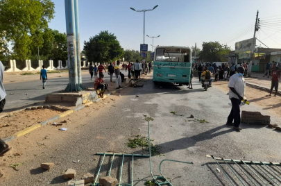 المتظاهرون يدفعون أحد الباصات المتعطلة لاستخدامه كحاجز في شارع رئيسي بأم درمان (الترا سودان)
