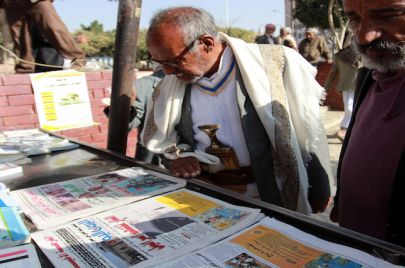 (Getty) يمنيون يطالعون عناوين الصحف المحلية 