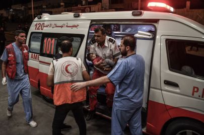 مسعف يحمل طفل رضيع بعد غارة إسرائيلية على خان يونس