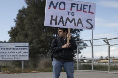 إسرائيلي يحمل لافتة ضد دخول المساعدات الإنسانية إلى قطاع غزة