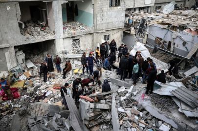 فلسطينيون فوق ركام المنازل المدمرة في مخيم النصيرات وسط قطاع غزة