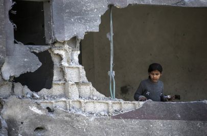 طفلة فلسطينية تنظر إلى الدمار الذي خلّفه القصف الإسرائيلي