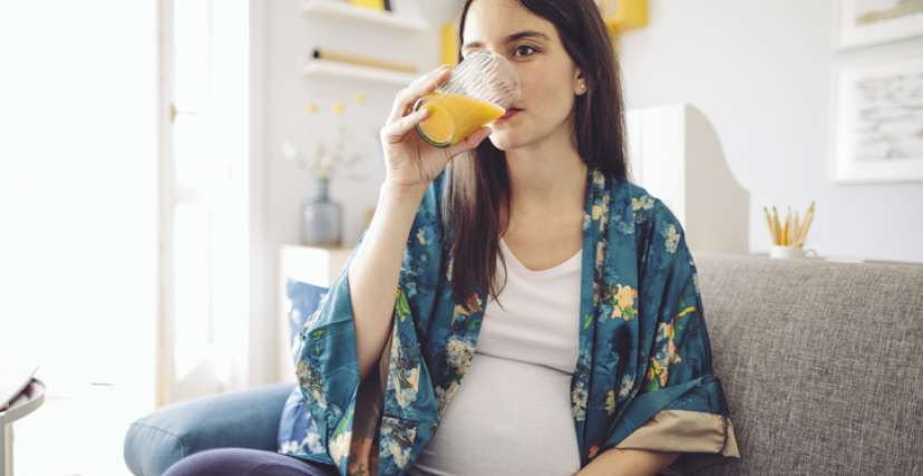 Happy pregnant women drinking orange juice