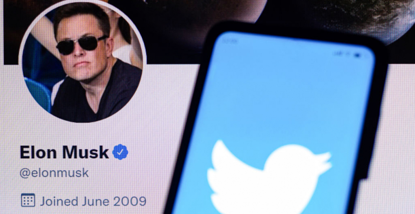 Twitter logo is displayed on a smartphone with Elon Musk's official Twitter profile