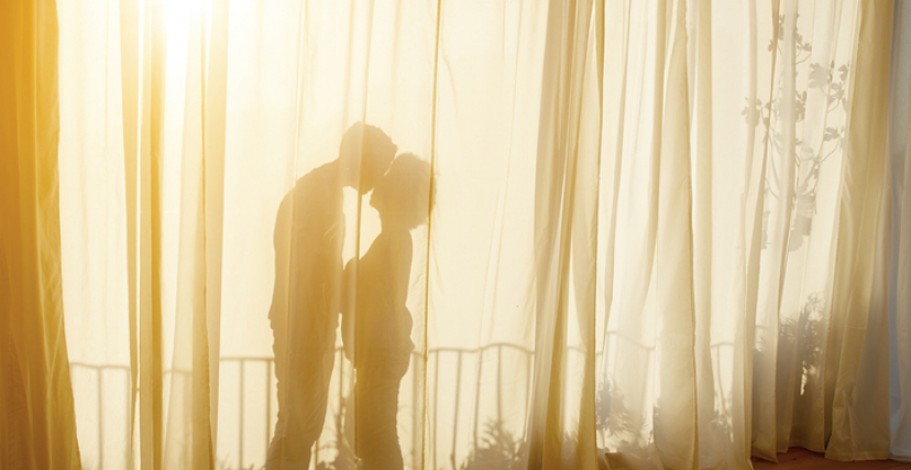 40's Couple In Apartment kissing behind curtain in the sun
