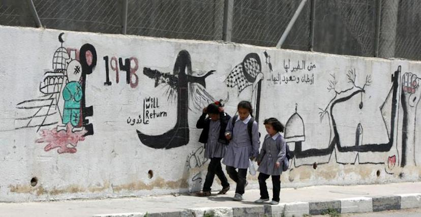 أطفال أمام غرافيتي في مدينة الخليل