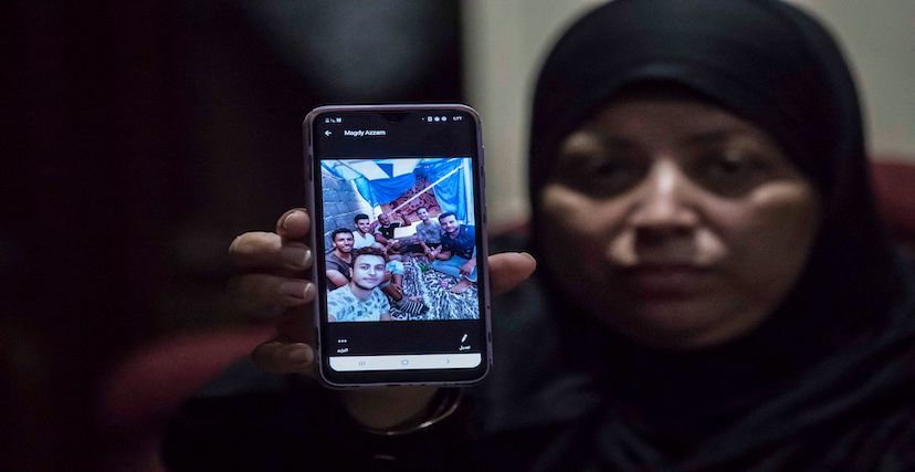مصرية ترفع صورة لأقاربها الذين فُقدوا في ليبيا أثناء محاولتهم الوصول إلى أوروبا في 2020