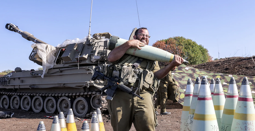 جندي إسرائيلي يحرك قذيفة مدفعية 155 ملم بالقرب من الحدود اللبنانية
