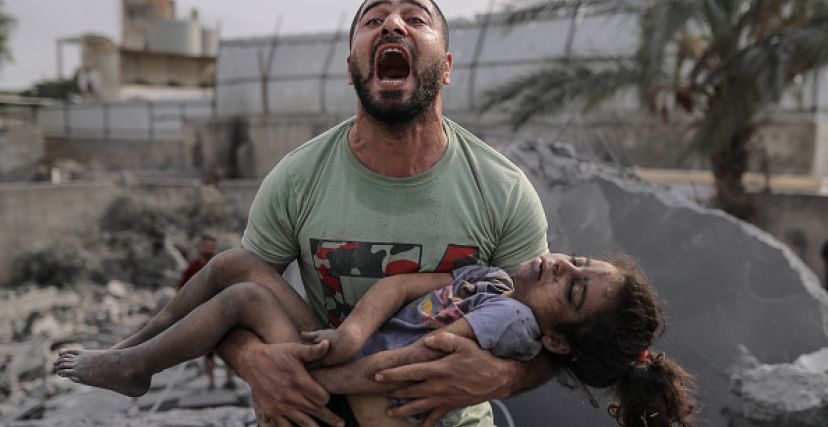 غزي يحمل طفلته الشهيدة