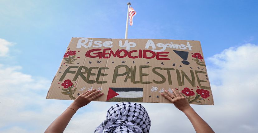 متظاهر في ماليزيا يرفع لوحة مؤيدة لفلسطين