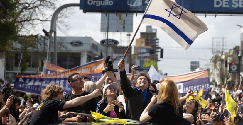 خافيير ميلي رافعًا علم إسرائيل بعد فوز في الانتخابات الرئاسية (GETTY)