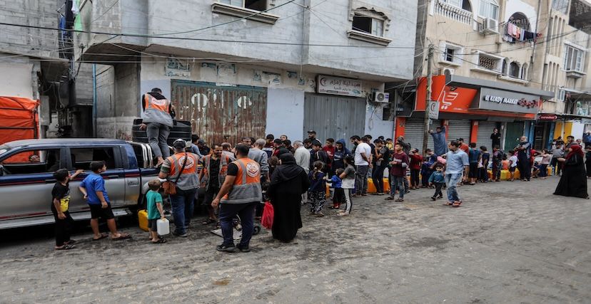 فلسطينيون ينتظرون في طابور للحصول على مياه الشرب في رفح