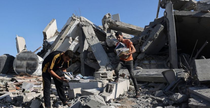 شابان يجمعان الكتب من مركز ثقافي دمّره الاحتلال في غزة