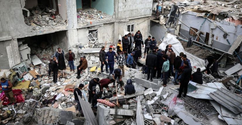 فلسطينيون فوق ركام المنازل المدمرة في مخيم النصيرات وسط قطاع غزة