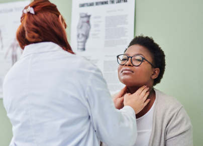 a doctor examining a woman’s throat during a consultation