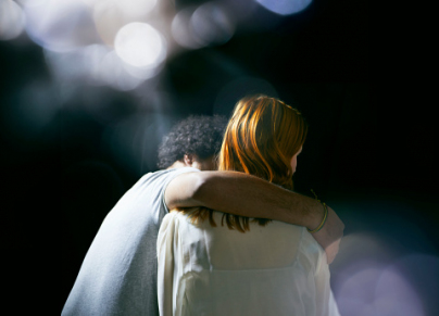 man hugging woman with lens flare
