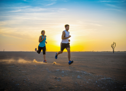 man and woman running in a desert 