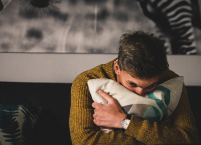 Portrait Of Man Hugging A Pillow At Home