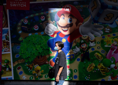 A pedestrian walks past a Nintendo Switch and Mario