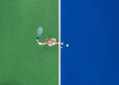 Drone shot above a female tennis player and her shadow