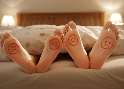couples unhappy feet in bed