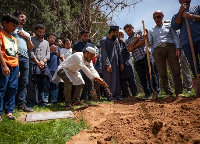 eople sprinkle dirt over the grave of Muhammad Afzaal Hussain, 27, at Fairview Memorial Park in Albuquerque 