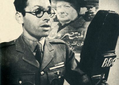 جندي يقرأ نداءً بالعربية في الإذاعة وتظهر خلفه صورة رئيس الوزراء البريطاني خلال الحرب العالمية الثانية ونستون تشرشل (Getty)